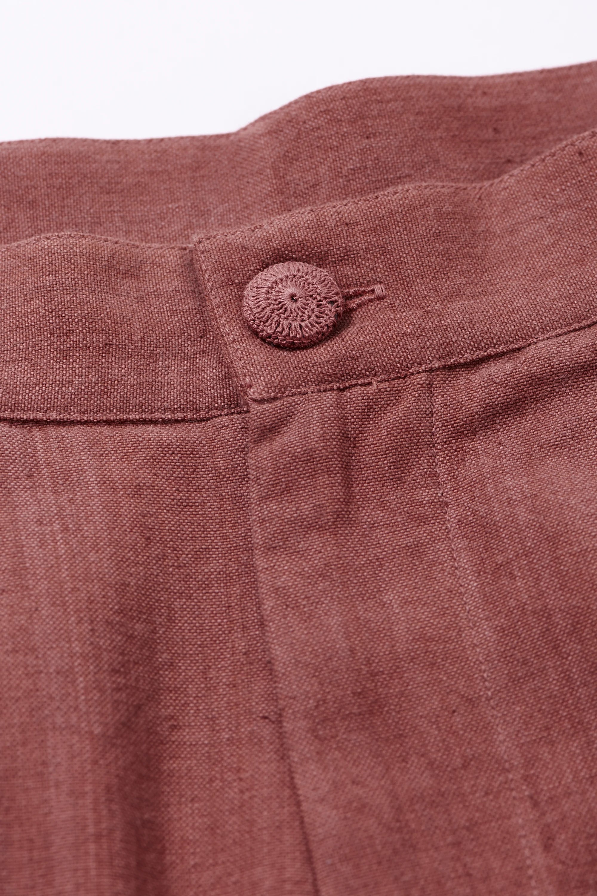 Close-up of Rogue pink  pants with a button 