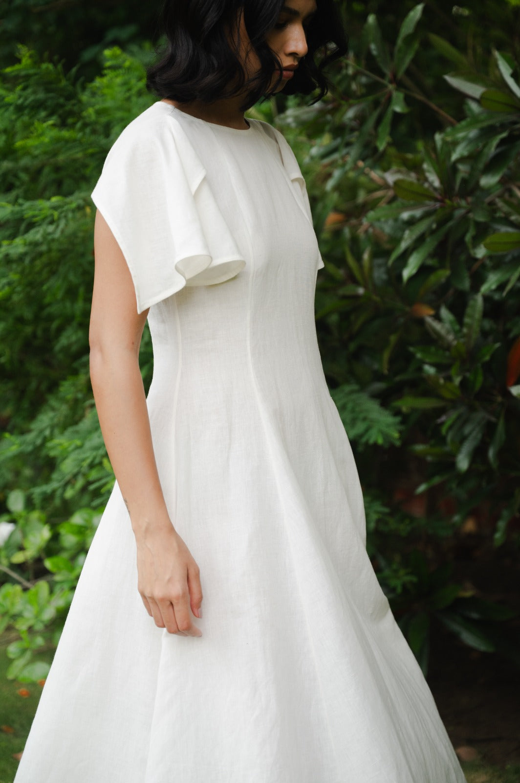A side shot of a woman wearing ecru dress