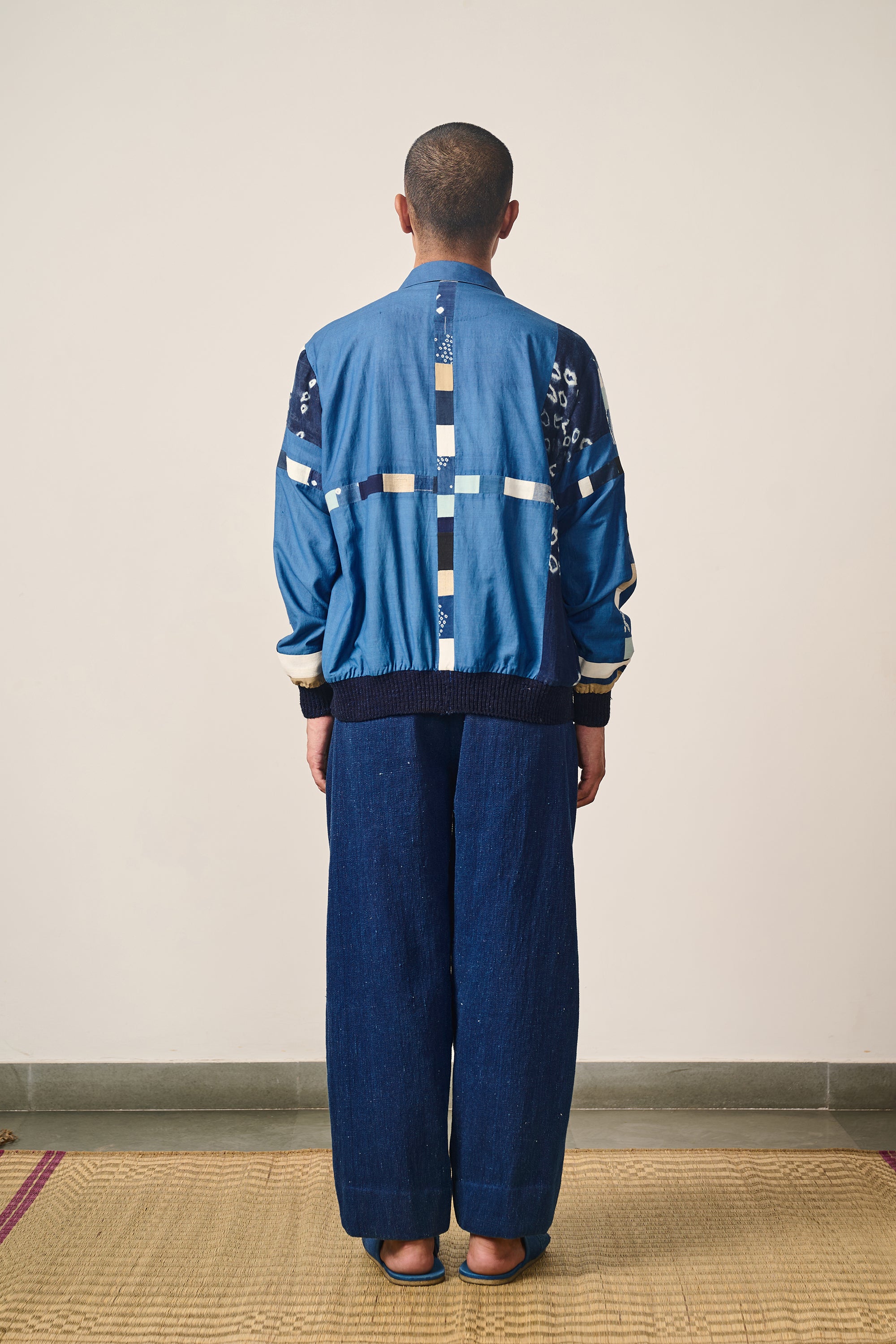 A back shot of a man wearing indigo jacket