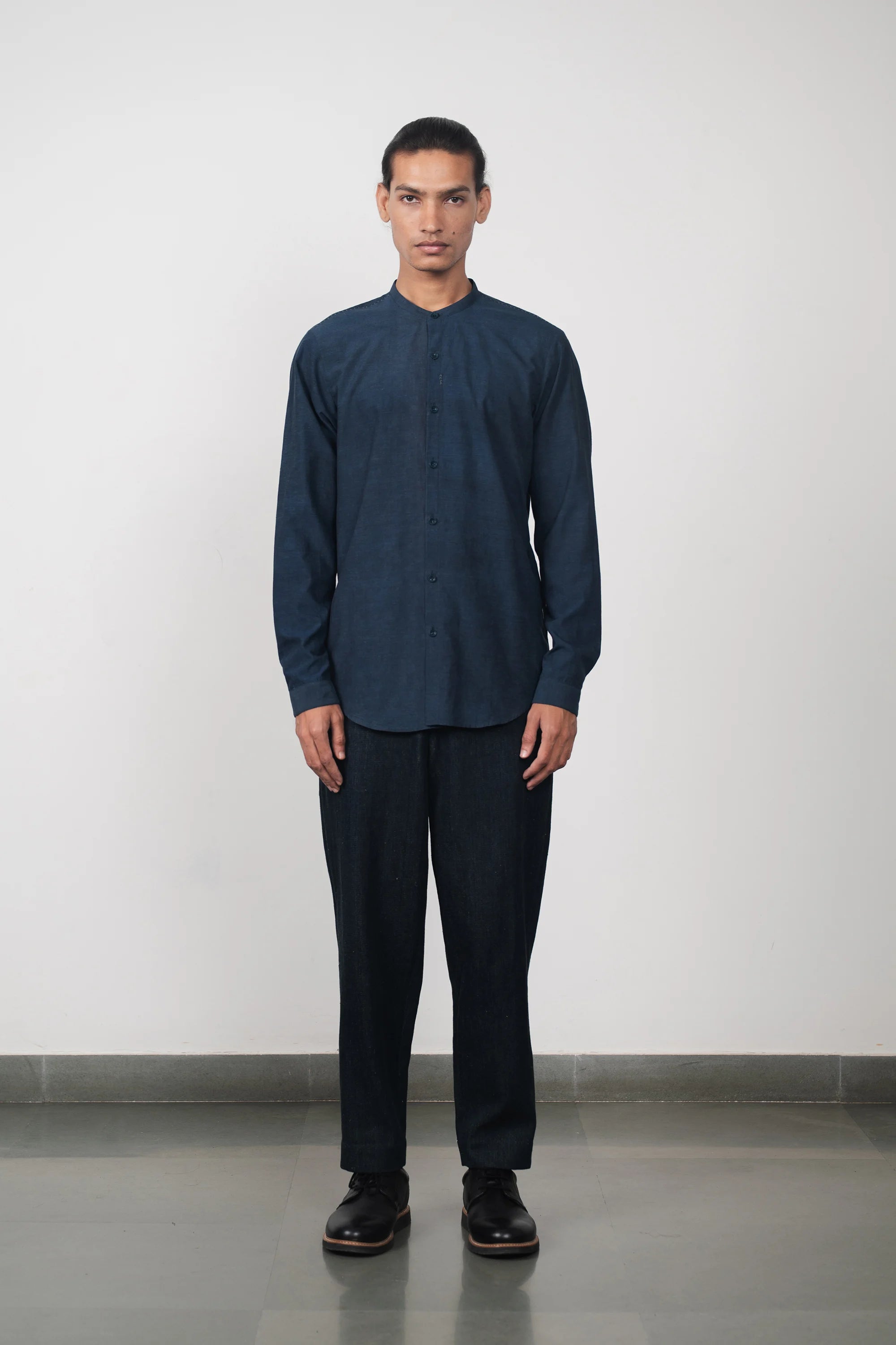 A man wearing indigo band collar shirt
