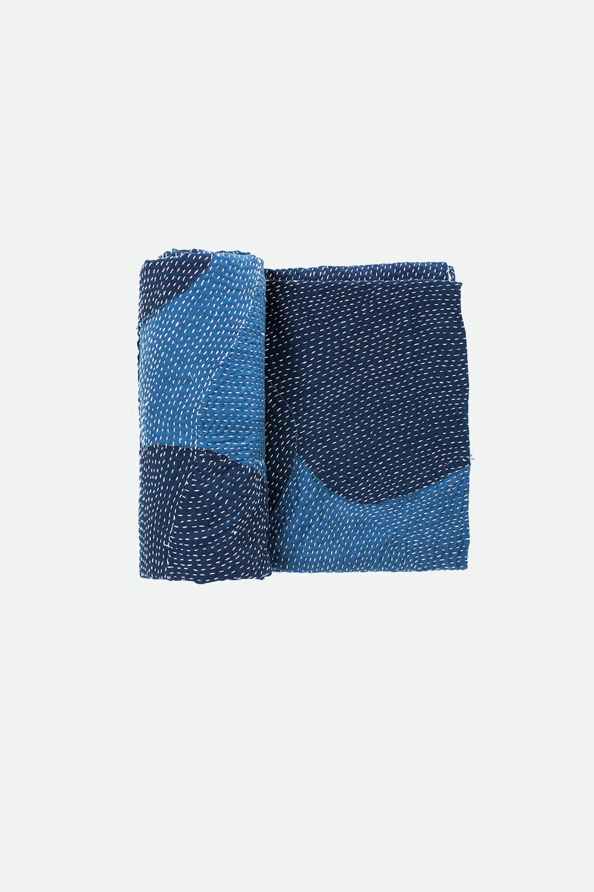 Indigo patterned fabric folded on a grey background
