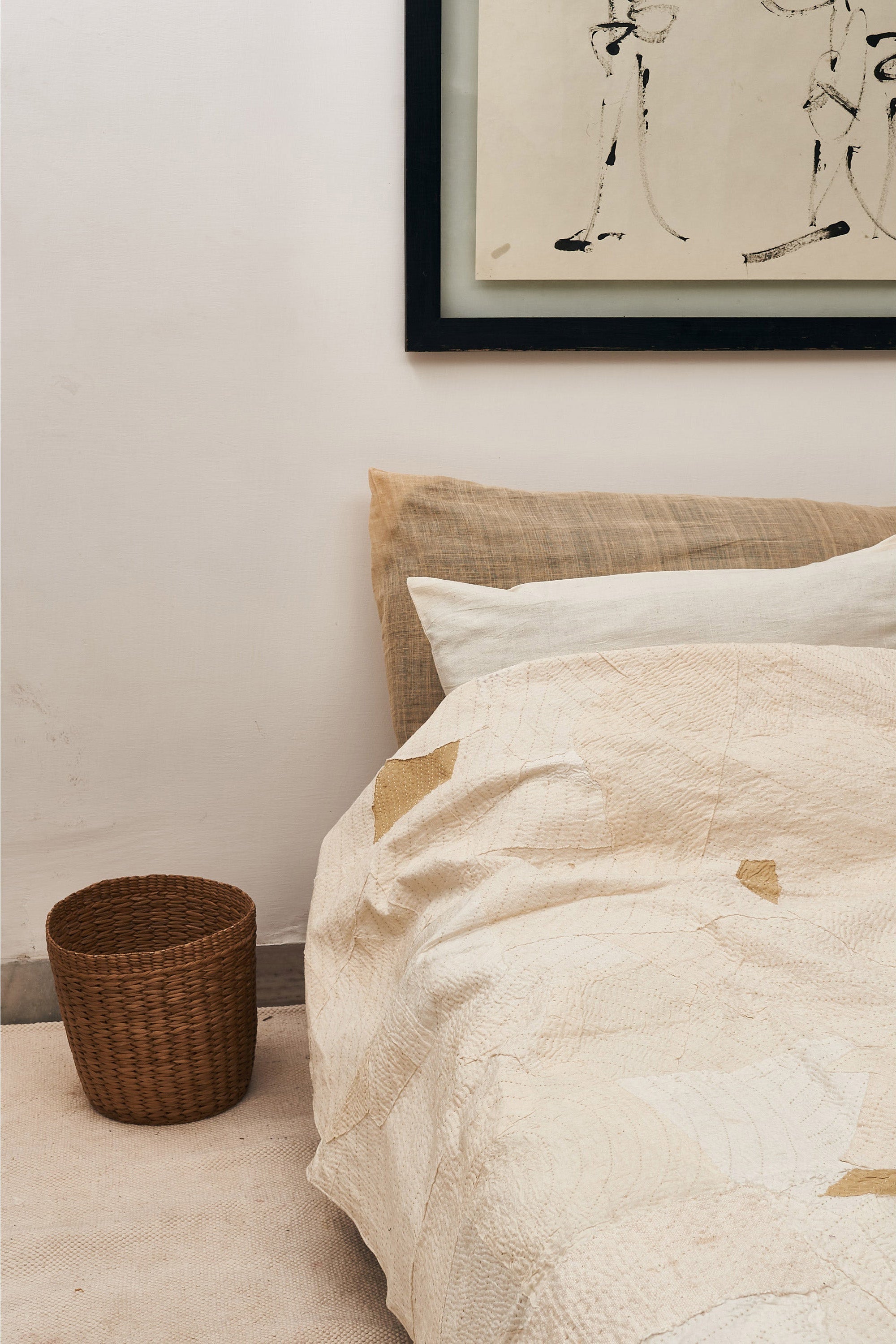 Ecru kantha bedding set on a bed with matching pillow